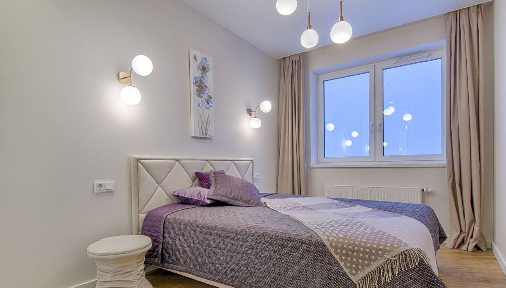 Camera da letto con illuminazione a soffitto e dietro il letto