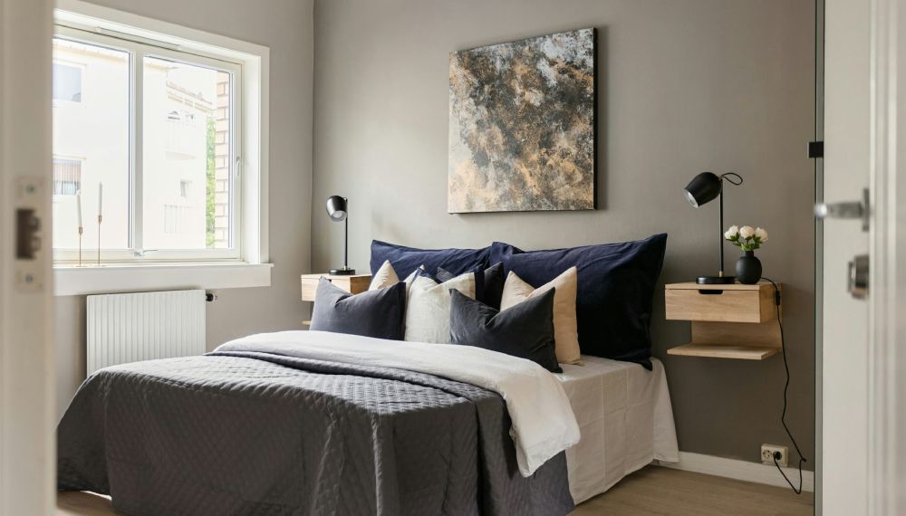 Letto con comodini sopra i quali sono appoggiate due lampade