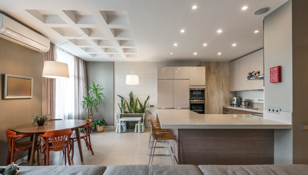 Open space moderno con divano, tavolo e cucina e controsoffitto illuminato