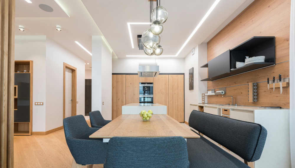 Cucina moderna con tavolo da pranzo in legno e illuminazione a led nel controsoffitto