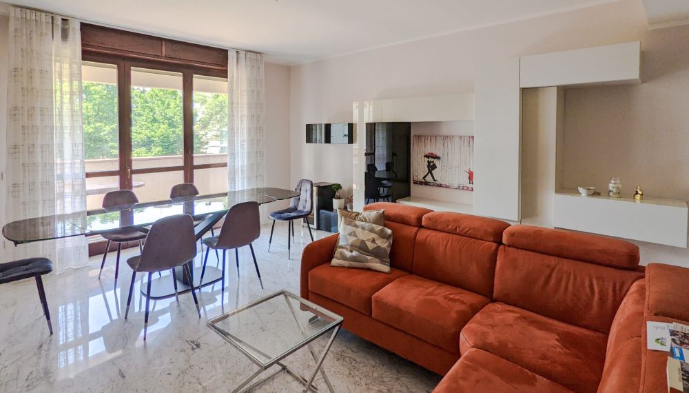 Living di una casa curato ed elegante con un divano rosso mattone